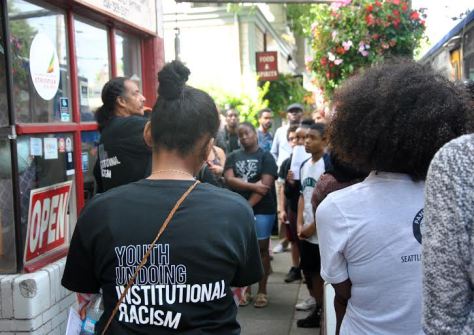 Aaron Dixon (far left) speaks with Freedom School students during the tour. (Photo: Celia Berk) 