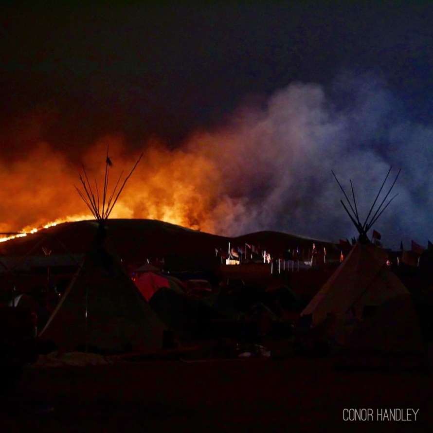 Fire on one side and the lights from DAPL construction and the police blockade on the other. No fire support came for over 7 hours. The fire was within a few hundred feet of camp just across the 1806 highway but the wind kept us safe and blew it in the other direction, towards the construction site.